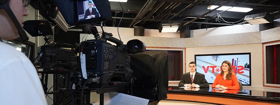 Student operates a camera during an SBU-TV newscast